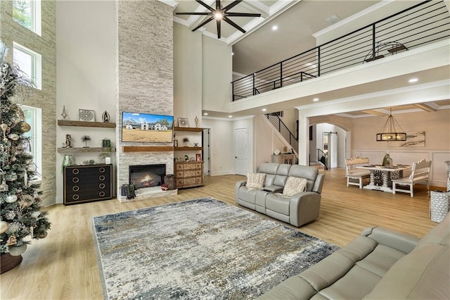 2634 Greenes Ln, Powder Springs, GA 30127 - living room featuring light wood-style flooring, a fireplace, a high ceiling, and a ceiling fan