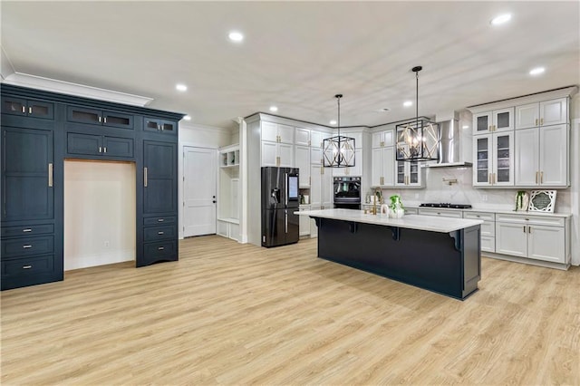 2634 Greenes Ln, Powder Springs, GA 30127 - kitchen with an island with sink, glass insert cabinets, light countertops, and black fridge