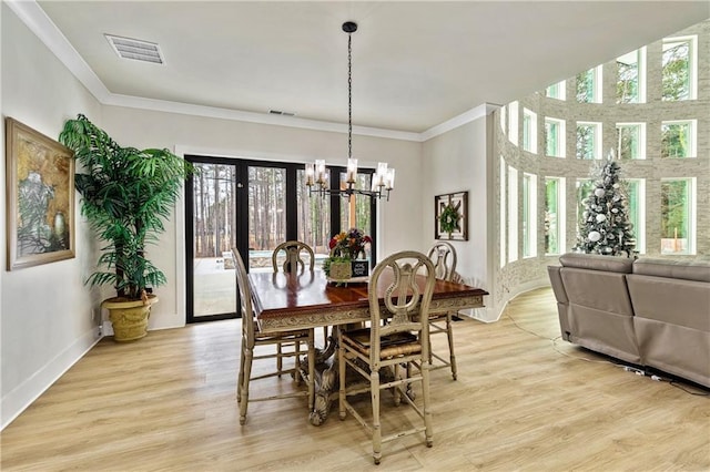 2634 Greenes Ln, Powder Springs, GA 30127 - dining room featuring a notable chandelier, plenty of natural light, visible vents, and light wood finished floors