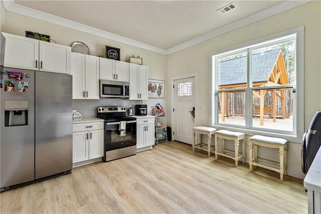 2634 Greenes Ln, Powder Springs, GA 30127 - kitchen featuring visible vents, white cabinets, light countertops, appliances with stainless steel finishes, and backsplash
