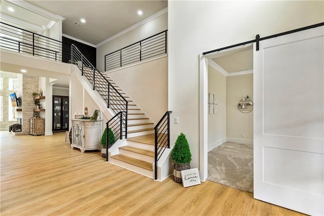 2634 Greenes Ln, Powder Springs, GA 30127 - foyer with a barn door, ornamental molding, wood finished floors, a high ceiling, and stairs