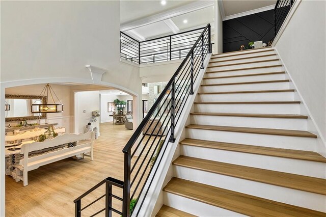 2634 Greenes Ln, Powder Springs, GA 30127 - stairway featuring arched walkways, wood finished floors, and a towering ceiling