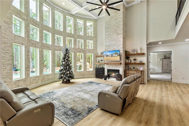 2634 Greenes Ln, Powder Springs, GA 30127 - living room featuring beam ceiling, light wood-style floors, a stone fireplace, coffered ceiling, and baseboards