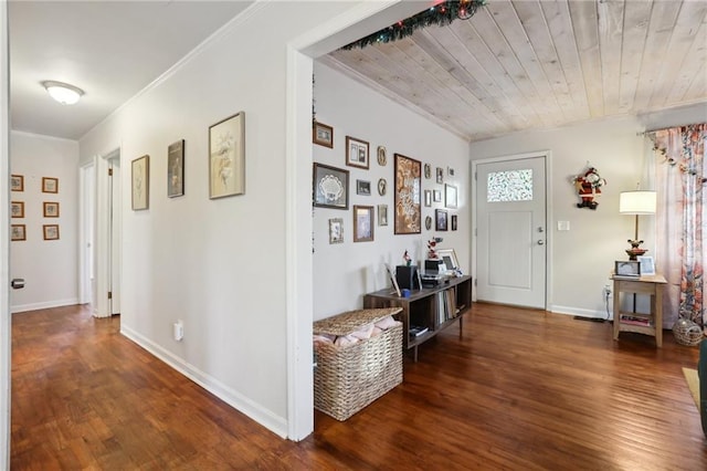 foyer entrance featuring ornamental molding, dark wood-type flooring, and wood ceiling