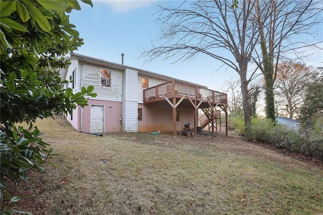 back of property featuring a wooden deck and a yard