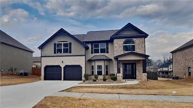 craftsman-style home with driveway, an attached garage, fence, and brick siding