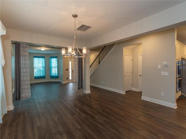 unfurnished living room featuring dark hardwood / wood-style floors and a chandelier