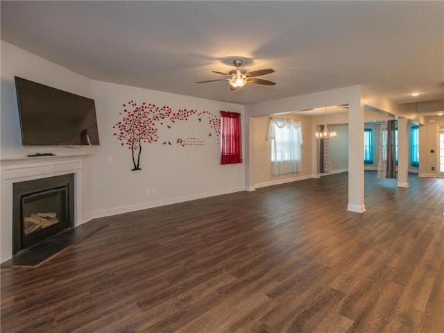 unfurnished living room featuring dark wood-type flooring and ceiling fan with notable chandelier