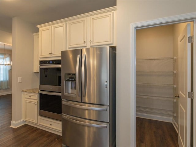 kitchen featuring white cabinetry, stainless steel appliances, and light stone counters