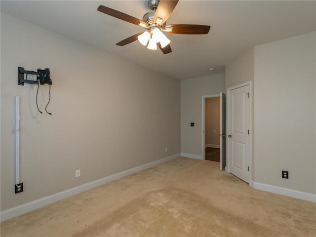 carpeted spare room featuring ceiling fan