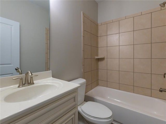 full bathroom with tiled shower / bath, vanity, and toilet