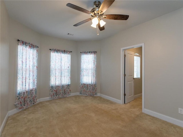 spare room featuring ceiling fan and light colored carpet