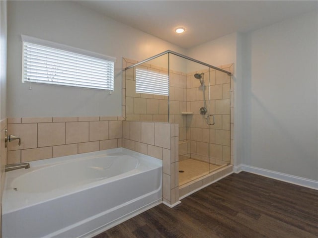 bathroom with hardwood / wood-style flooring and shower with separate bathtub