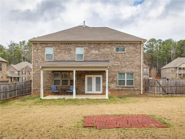 rear view of house with a patio area and a lawn