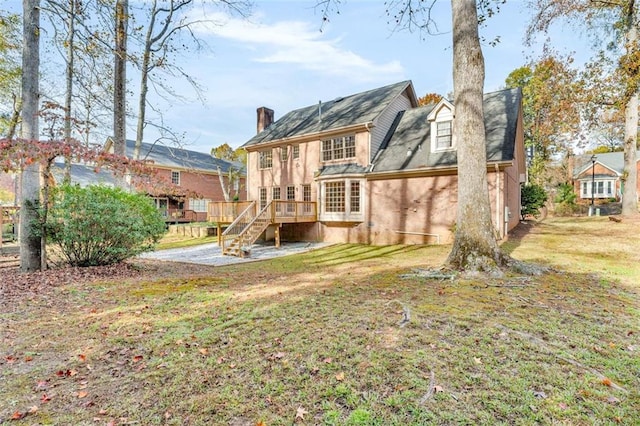 back of house with a lawn and a deck