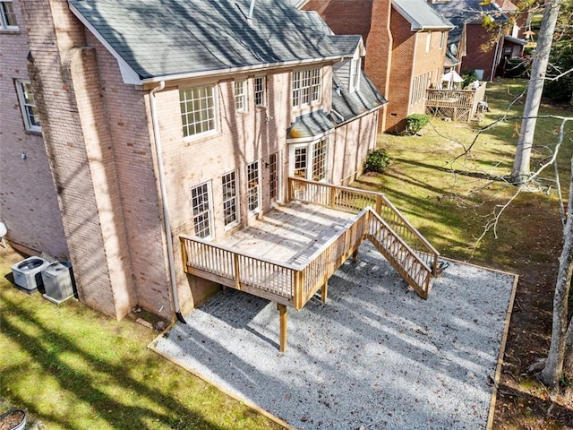 back of property with a deck and a lawn