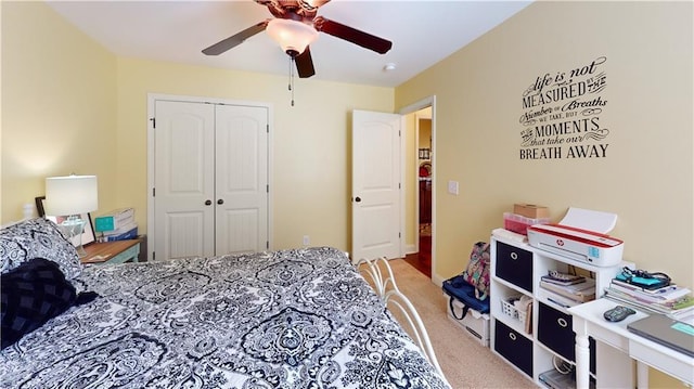 carpeted bedroom with ceiling fan and a closet