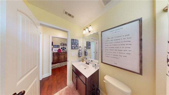 bathroom with vanity, wood-type flooring, and toilet