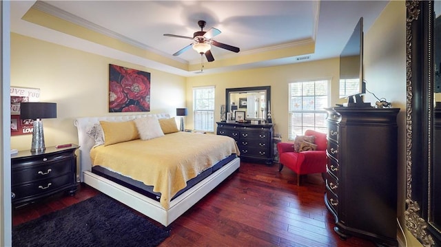 bedroom with a tray ceiling, ornamental molding, dark hardwood / wood-style floors, and ceiling fan