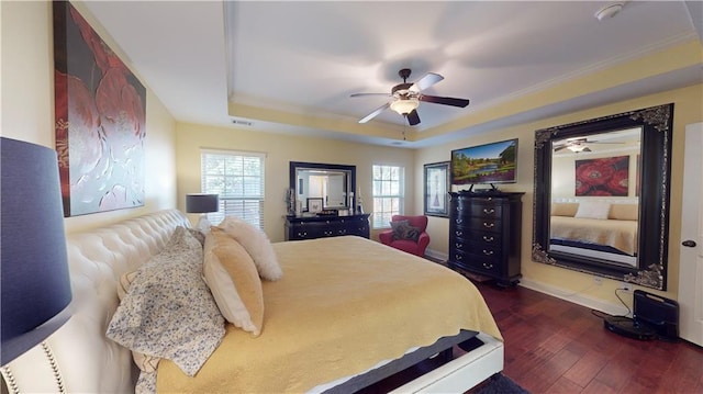 bedroom with crown molding, ceiling fan, a tray ceiling, and dark hardwood / wood-style flooring