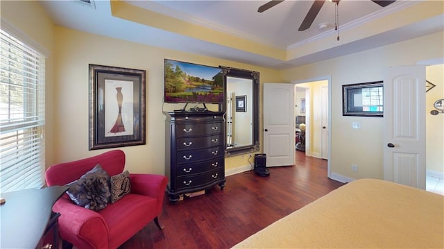 bedroom featuring a raised ceiling, dark hardwood / wood-style flooring, ceiling fan, and multiple windows