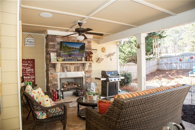 view of patio / terrace with area for grilling, an outdoor living space with a fireplace, and ceiling fan