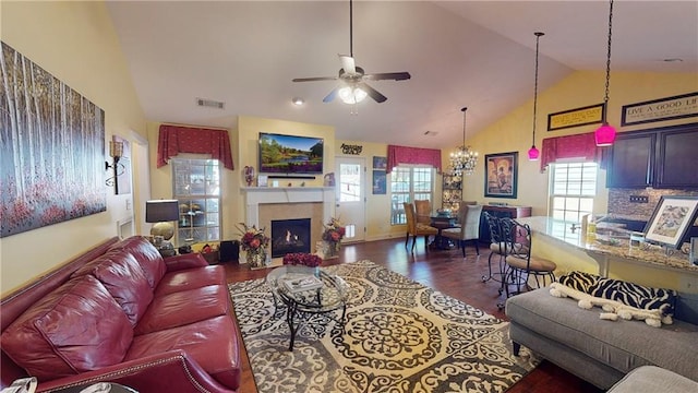 living room with lofted ceiling, dark hardwood / wood-style floors, and ceiling fan with notable chandelier