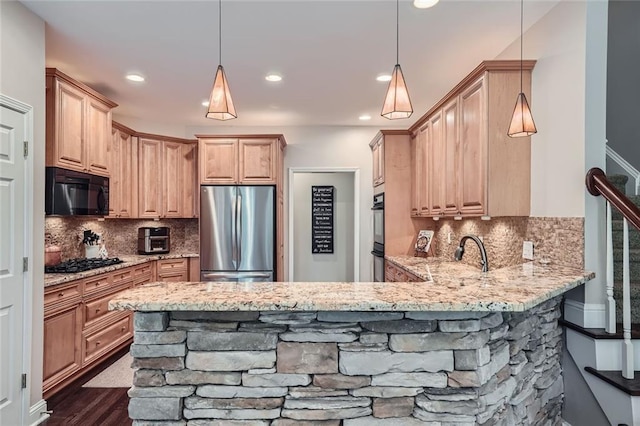 kitchen with light stone counters, a peninsula, light brown cabinetry, black appliances, and backsplash