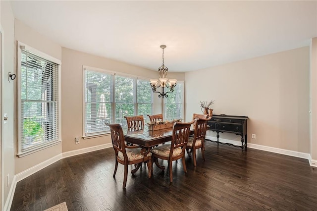 dining area featuring dark wood-style floors, a notable chandelier, and baseboards