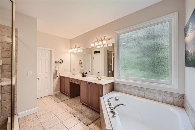 bathroom with tile patterned flooring, baseboards, double vanity, a bath, and a sink