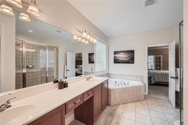 ensuite bathroom featuring visible vents, connected bathroom, a shower stall, and a sink