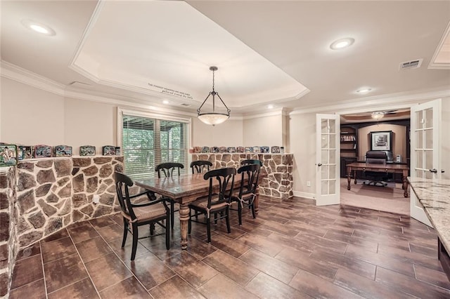 dining area featuring a tray ceiling, french doors, visible vents, and ornamental molding