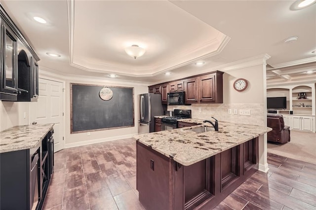 kitchen featuring a sink, stainless steel appliances, light stone countertops, and a peninsula