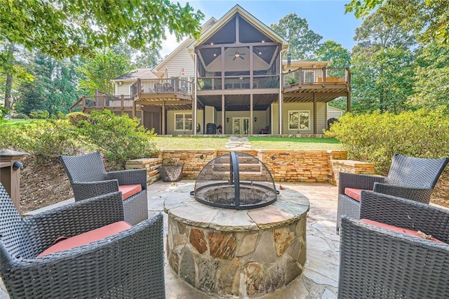 rear view of property featuring a patio, an outdoor fire pit, and a deck