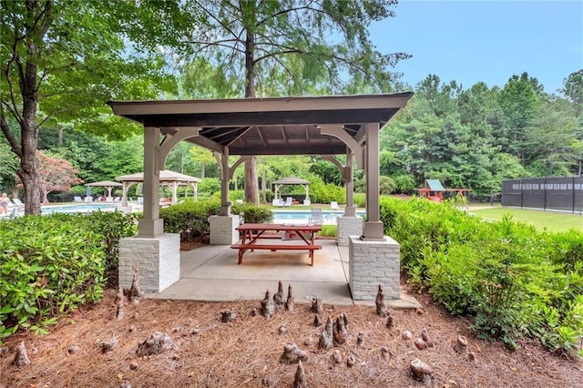 view of patio featuring a gazebo, a community pool, and fence