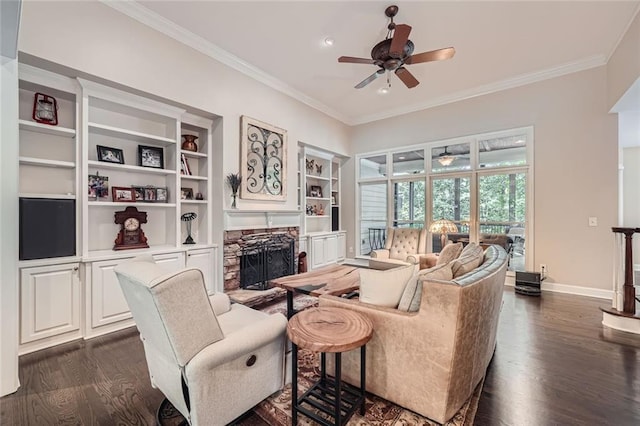 living room featuring a stone fireplace, crown molding, dark wood-type flooring, and ceiling fan