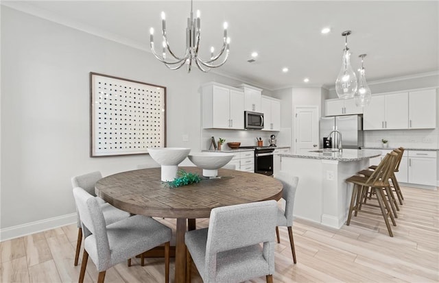 dining area with light hardwood / wood-style floors, crown molding, and a chandelier