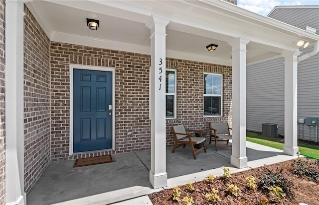 property entrance with covered porch and central AC unit