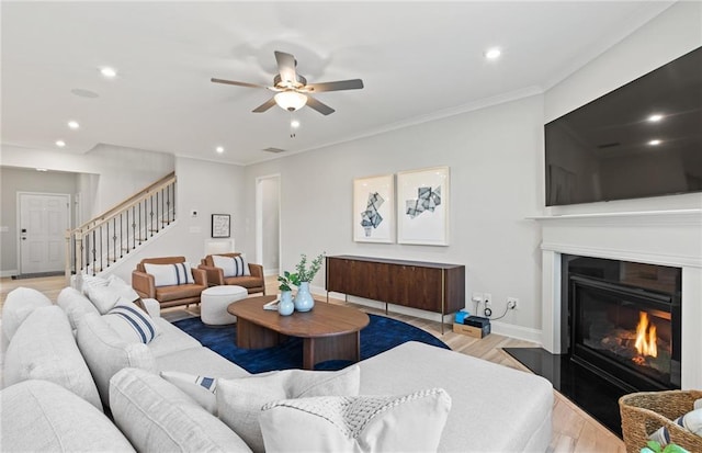 living room with ceiling fan, light hardwood / wood-style flooring, and ornamental molding