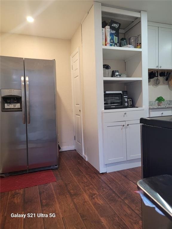 kitchen featuring light countertops, stainless steel refrigerator with ice dispenser, dark wood finished floors, and white cabinetry