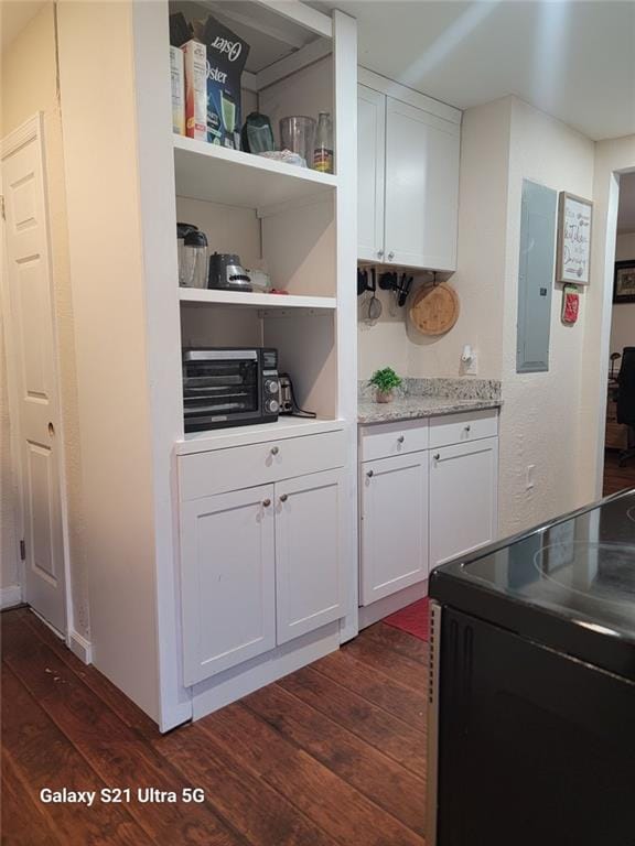 interior space with electric range, white cabinetry, electric panel, open shelves, and dark wood finished floors