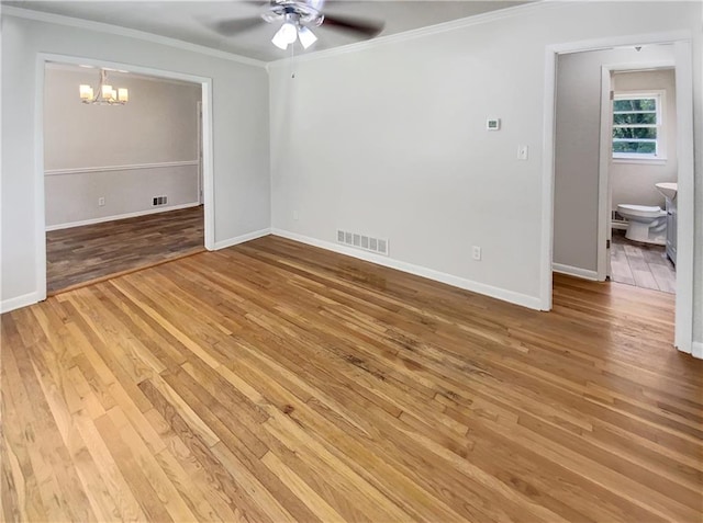 empty room with ceiling fan with notable chandelier, light hardwood / wood-style floors, and ornamental molding