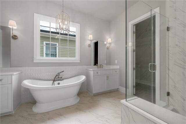 bathroom featuring tile walls, vanity, shower with separate bathtub, and a notable chandelier