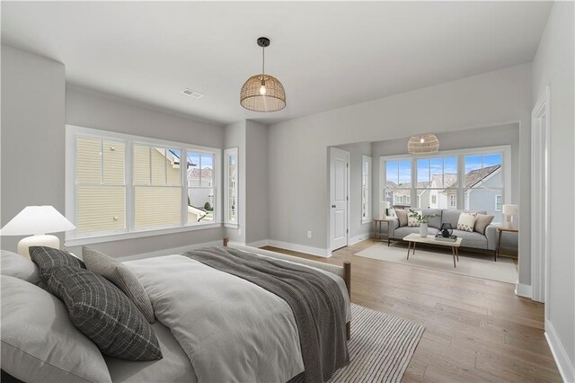 bedroom with light hardwood / wood-style flooring and multiple windows