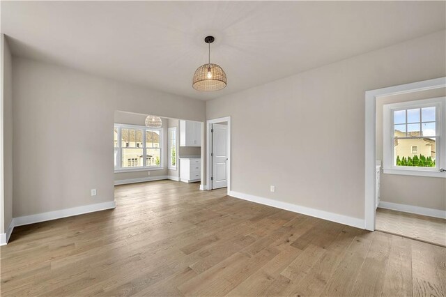 unfurnished living room featuring wood-type flooring and plenty of natural light