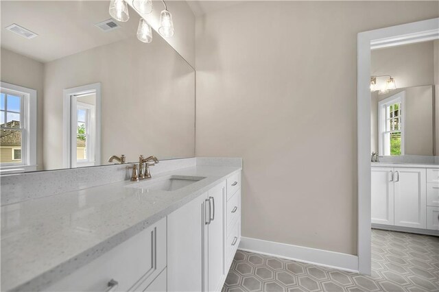 bathroom with vanity, a healthy amount of sunlight, and tile patterned floors