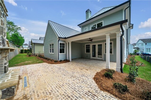 back of property featuring french doors, a lawn, and ceiling fan