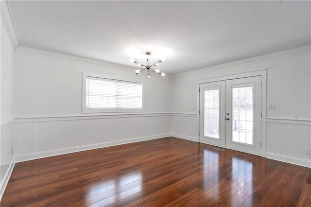 spare room with hardwood / wood-style flooring, a notable chandelier, french doors, and a wealth of natural light