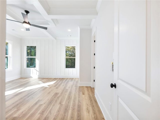 empty room featuring beamed ceiling, ceiling fan, light hardwood / wood-style flooring, crown molding, and coffered ceiling