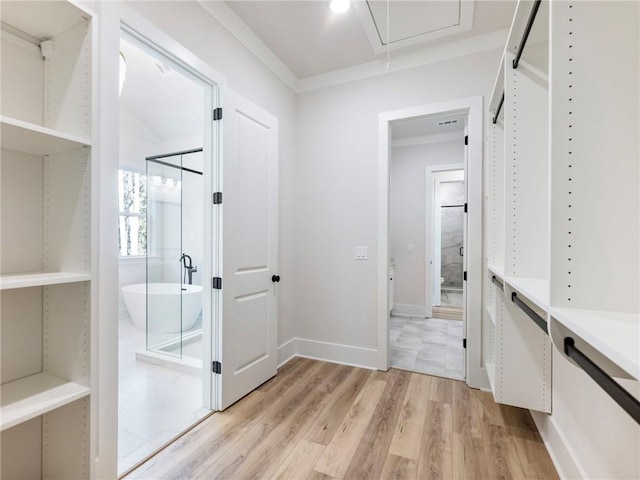 walk in closet with light wood-type flooring and vaulted ceiling